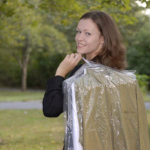 woman carrying dry cleaning 960x